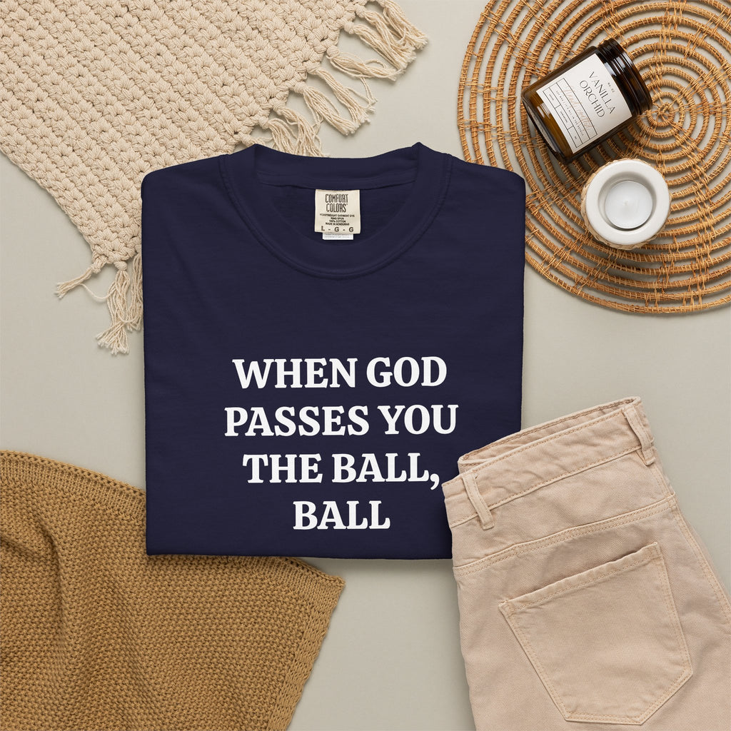 True Navy When God Passes You The Ball, Ball tee folded in a flat lay with jeans and candle