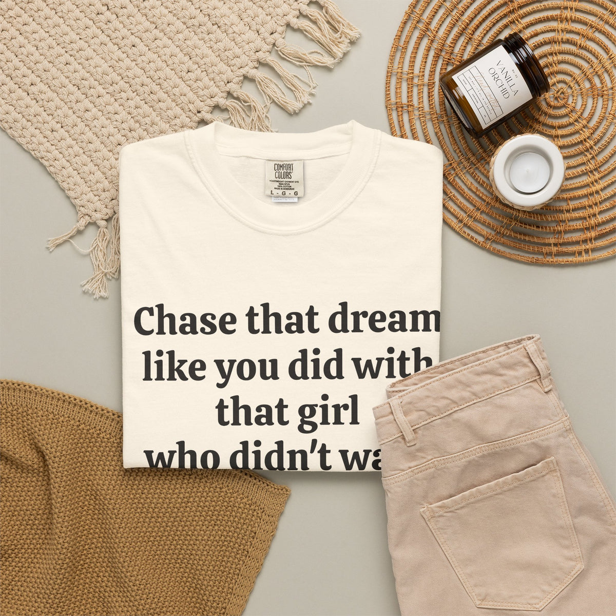 Ivory Chase That Dream tee folded in a flat lay with jeans and candle