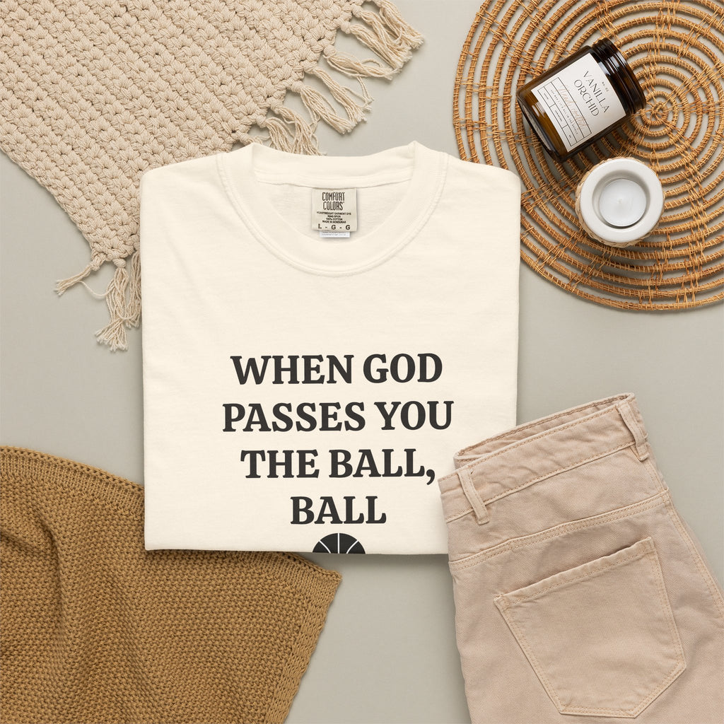 Ivory When God Passes You The Ball, Ball tee folded in a flat lay with jeans and candle