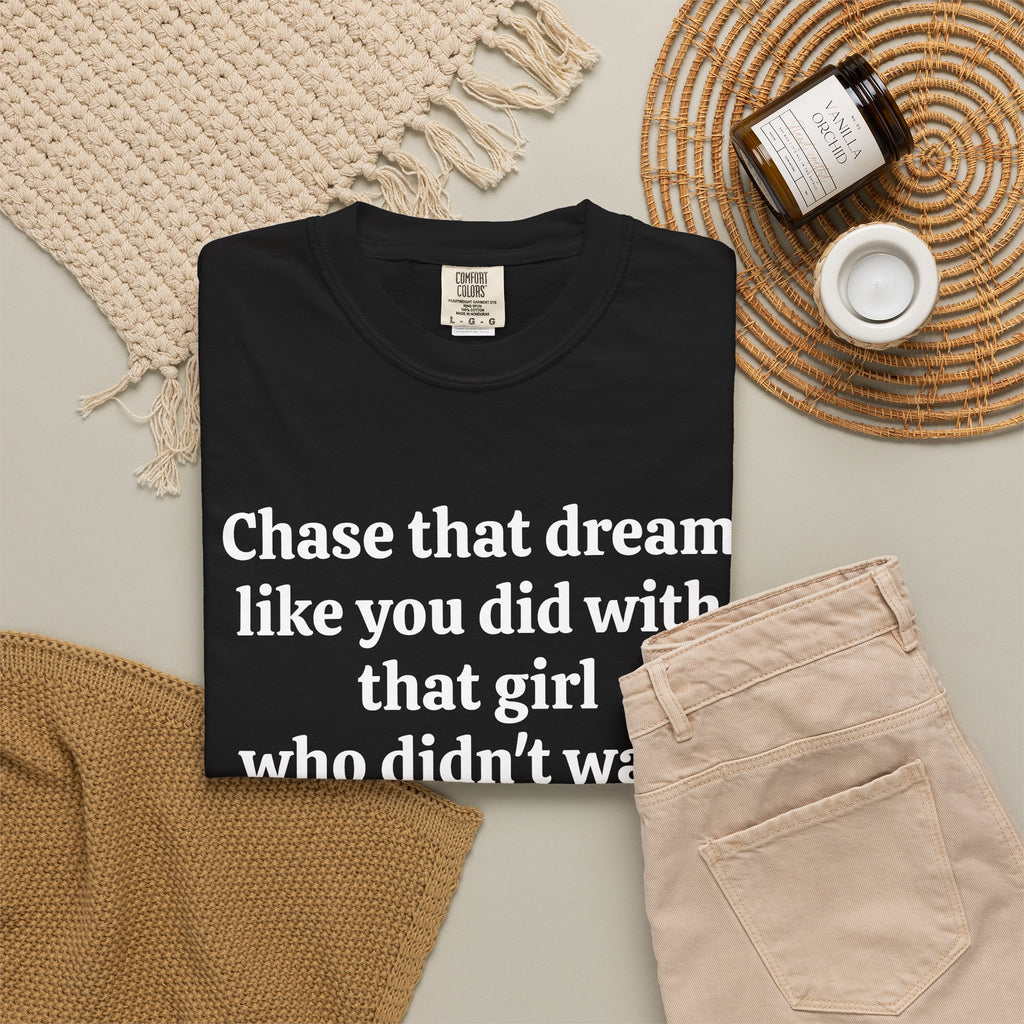 Black Chase That Dream tee folded in a flat lay with jeans and candle